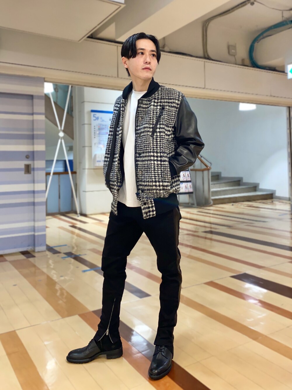 ブラック系のデニムパンツ、ブラック系のブルゾン、ブラック系のブーツを着用したメンズの冬コーディネートの1枚目の写真