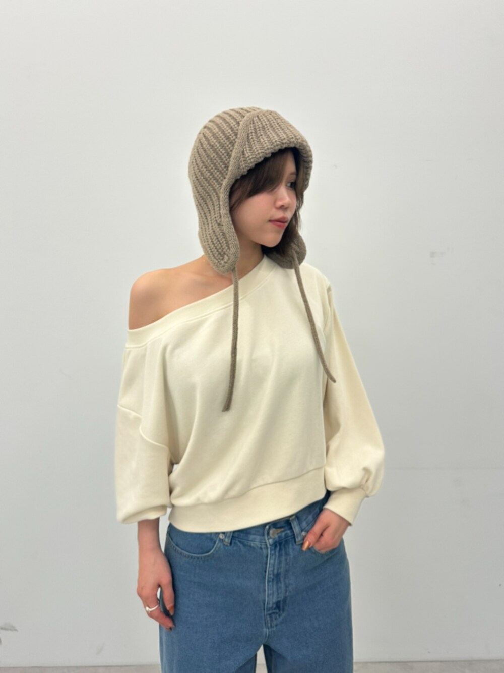 ブルー系のデニムパンツ、ピンク系のスウェットを着用したレディースの秋コーディネートの1枚目の写真