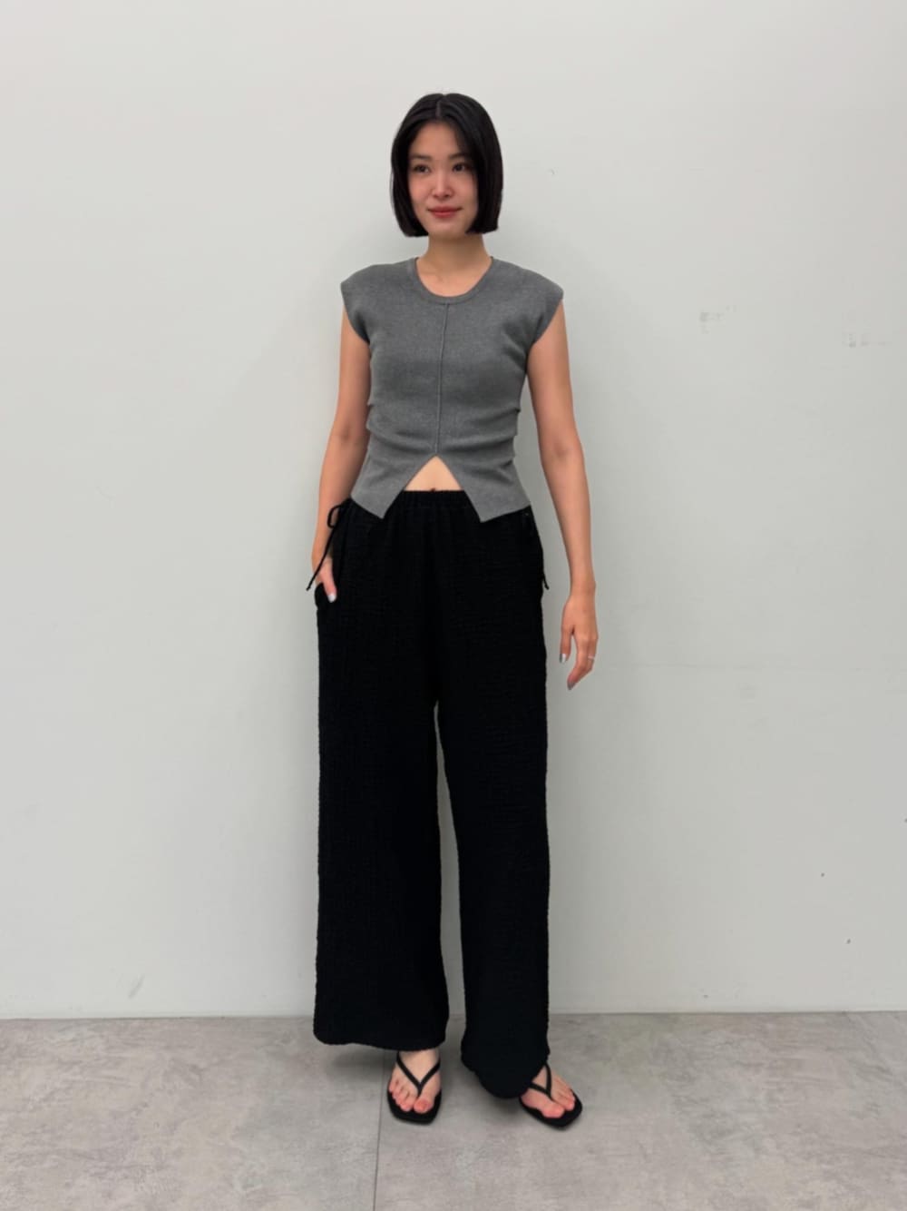 グレー系のニット/セーター、ブラック系のその他パンツを着用したレディースの夏コーディネートの1枚目の写真