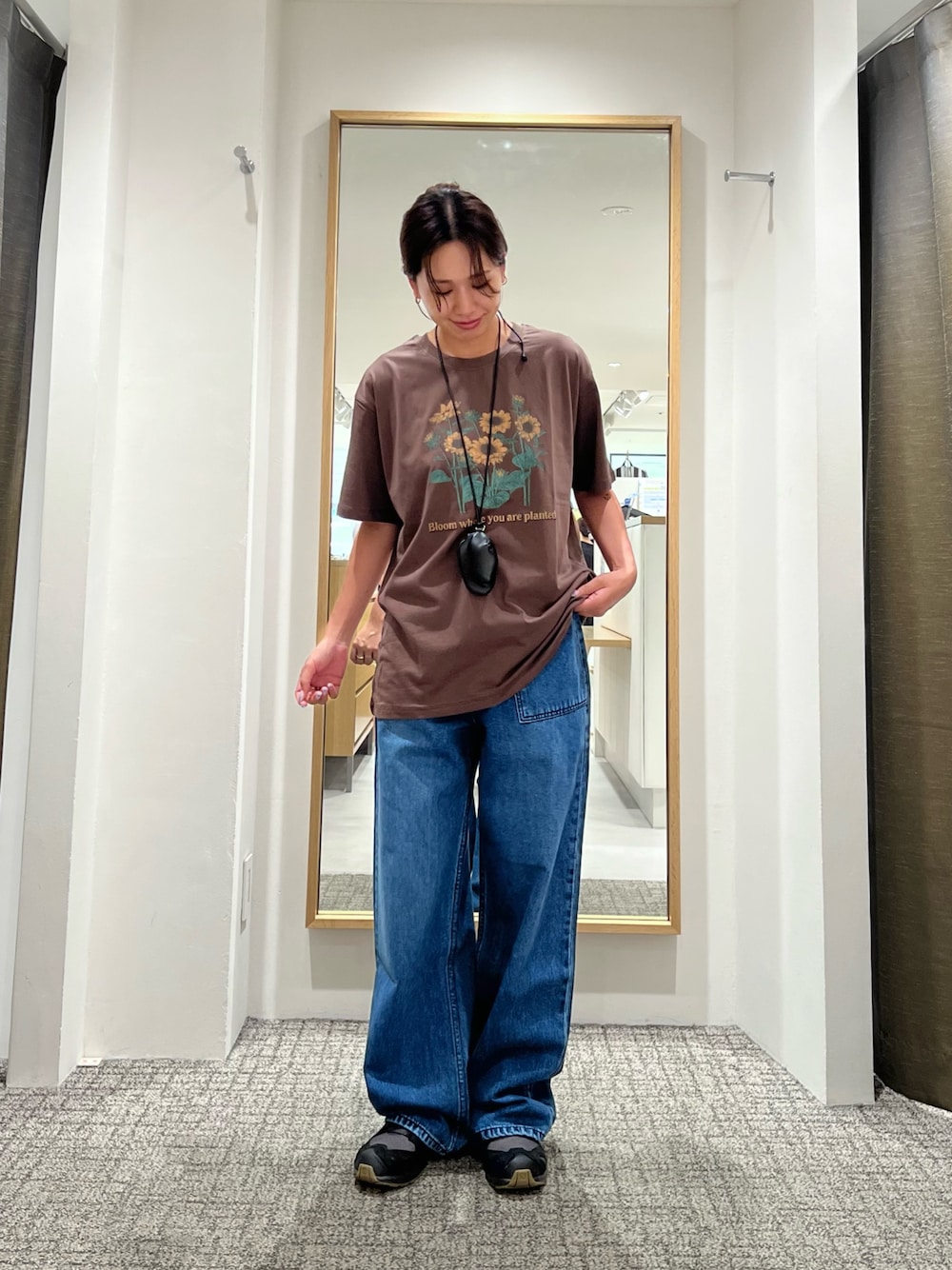 ブラック系のショルダーバッグ、ブラウン系のTシャツ/カットソー、ブルー系のデニムパンツを着用したレディースの夏コーディネートの1枚目の写真