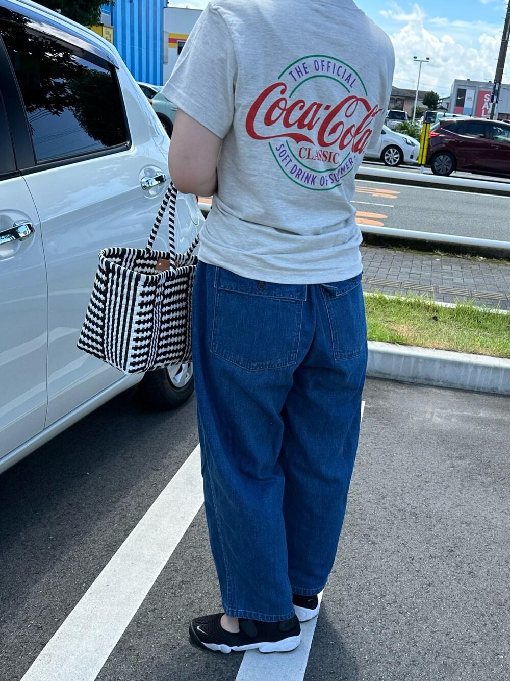 ブルー系のデニムパンツ、ベージュ系のTシャツ/カットソーを着用したレディースの夏コーディネートの1枚目の写真