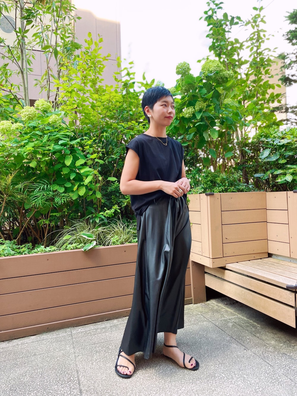 ブラック系のTシャツ/カットソー、ブラック系のスカート、ブラック系のサンダルを着用したレディースの夏コーディネートの1枚目の写真