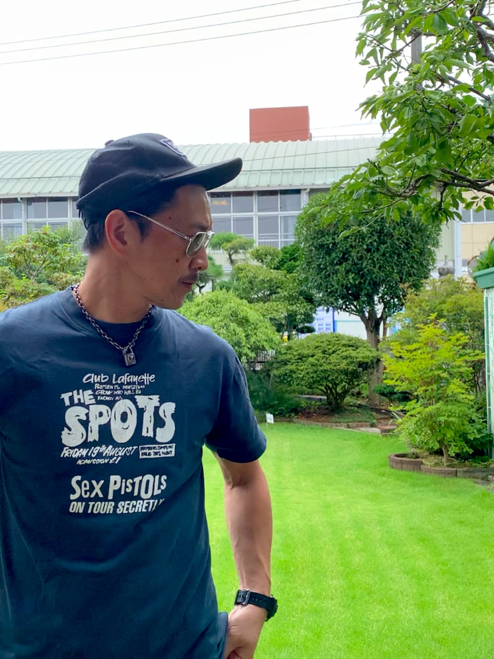 ブラック系のTシャツ/カットソー、ブラック系のキャップ、グレー系のサングラスを着用したメンズの夏コーディネートの1枚目の写真