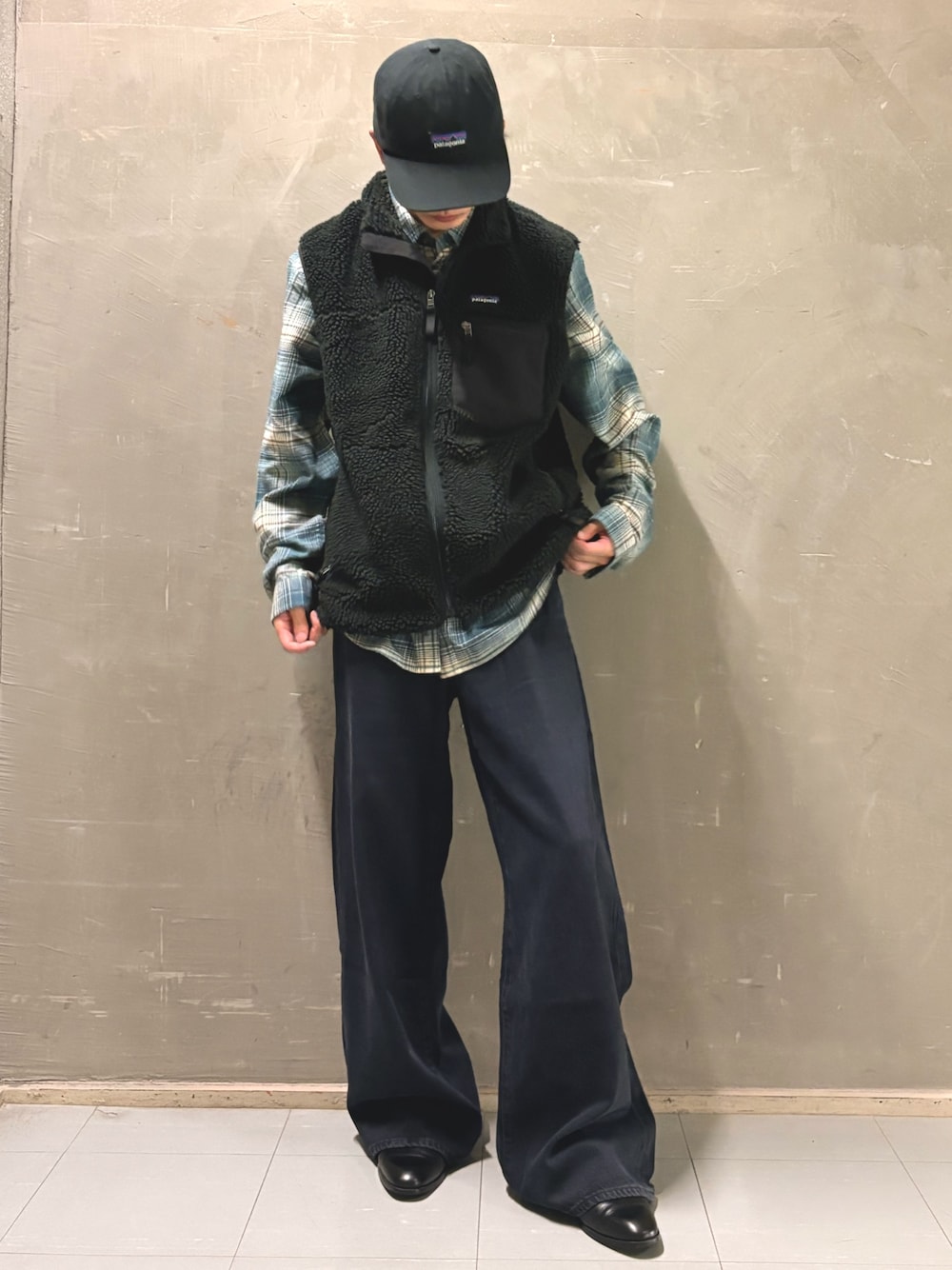 ブラック系のベスト、ブルー系のシャツ/ブラウス、ブラック系のデニムパンツを着用したメンズの秋コーディネートの1枚目の写真