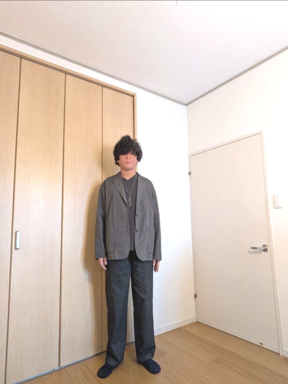 グレー系のテーラードジャケット、ブルー系のパンツを着用したメンズの春コーディネートの1枚目の写真
