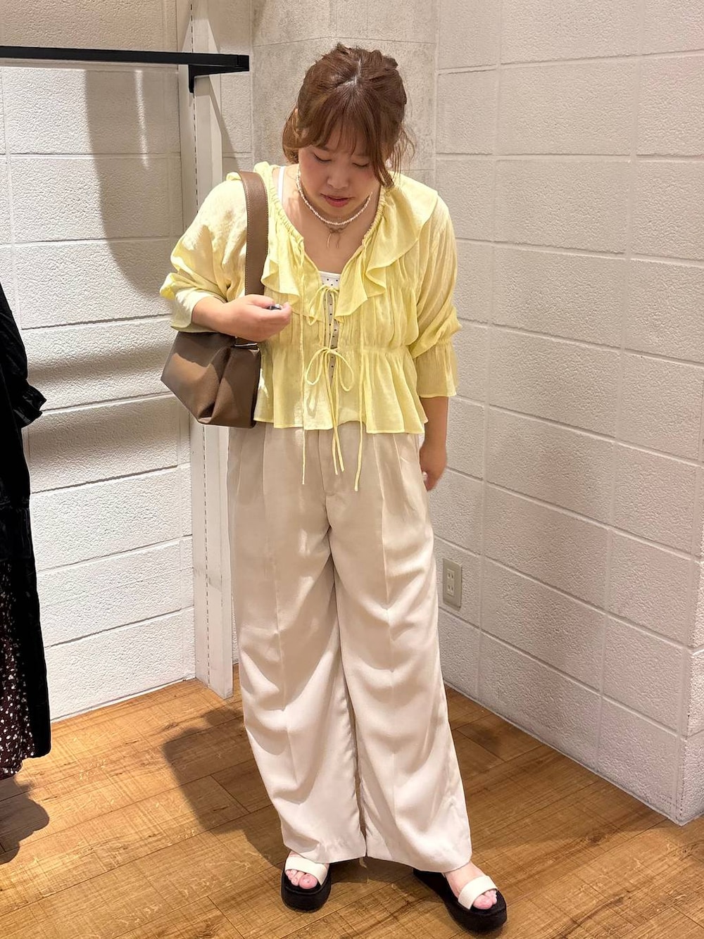 ホワイト系のTシャツ/カットソー、ホワイト系のスラックス、ホワイト系のサンダルを着用したレディースの春コーディネートの1枚目の写真
