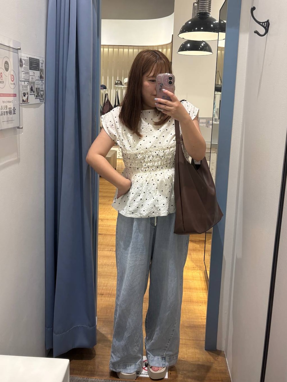 ブラウン系のショルダーバッグ、ブルー系のデニムパンツ、ホワイト系のサンダルを着用したレディースの夏コーディネートの1枚目の写真