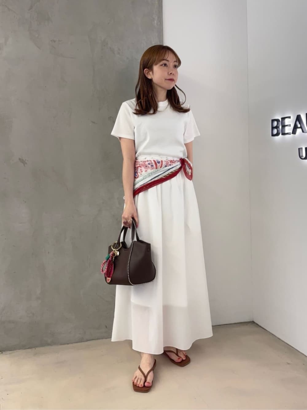 ホワイト系のTシャツ/カットソー、ホワイト系のスカート、ブラウン系のショルダーバッグを着用したレディースの夏コーディネートの1枚目の写真