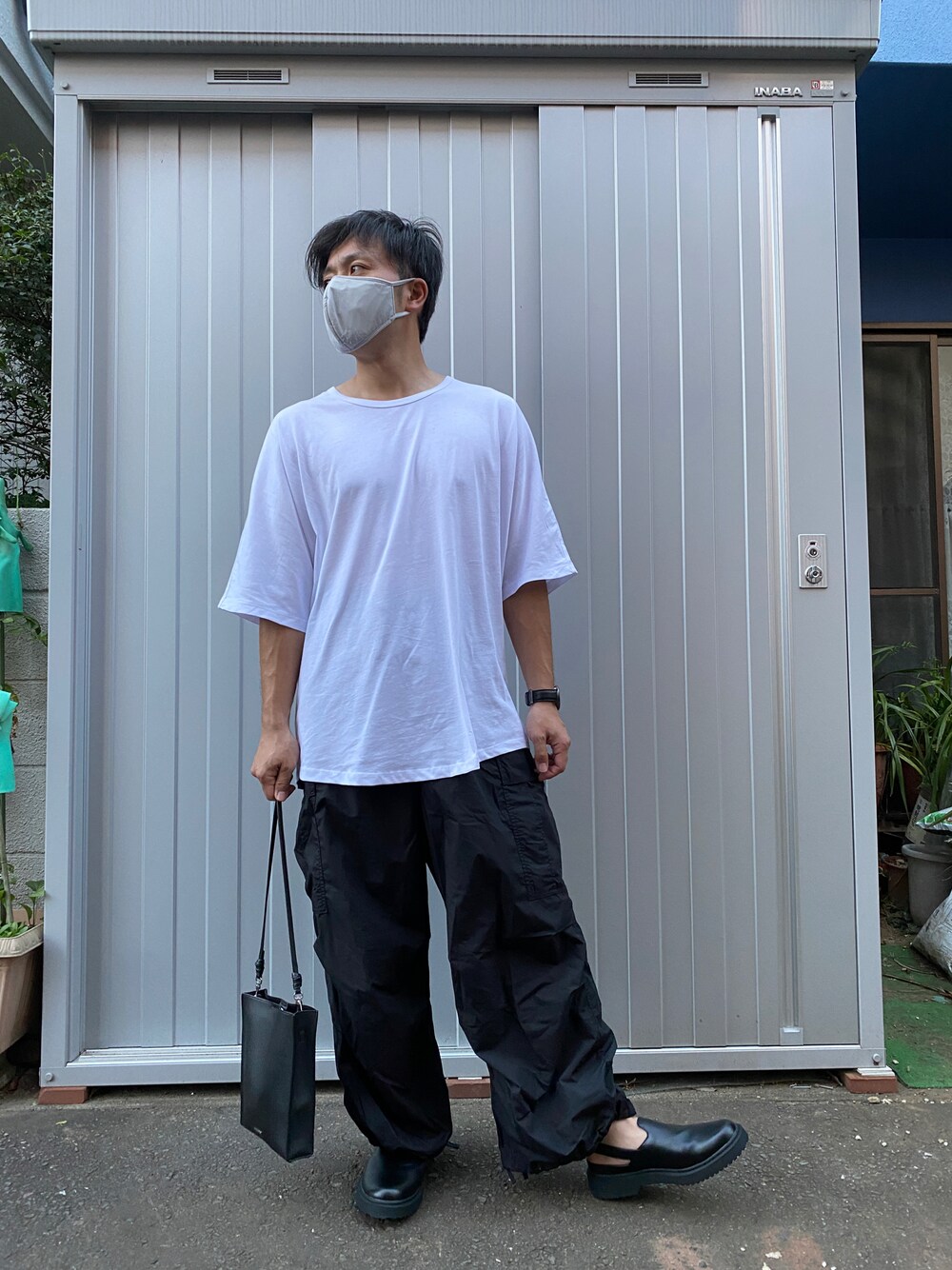 ホワイト系のTシャツ/カットソー、ブラック系のカーゴパンツ、ブラック系のサンダルを着用したメンズの夏コーディネートの1枚目の写真