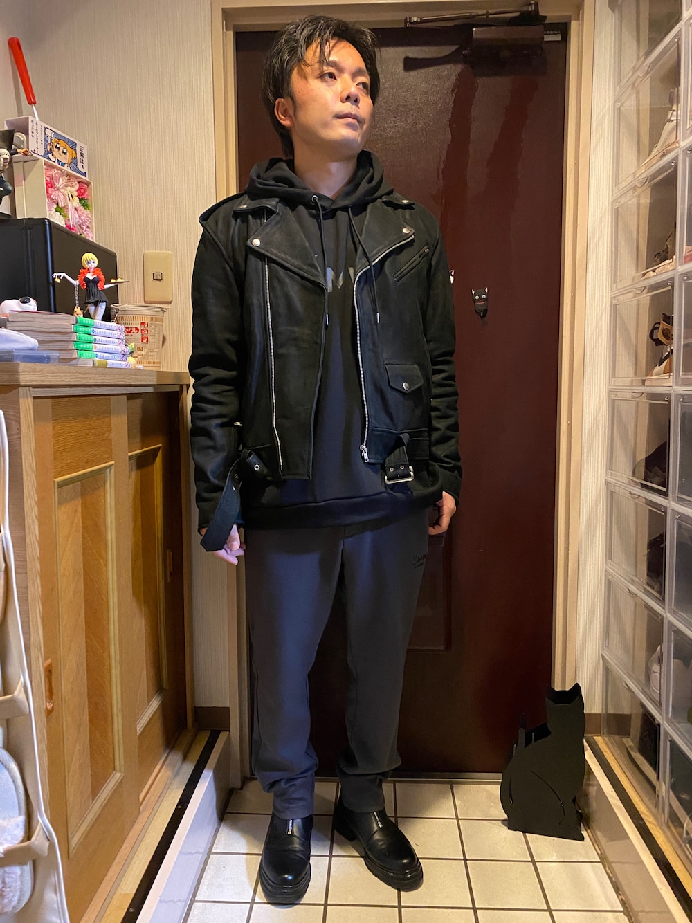 グレー系のスウェットパンツ、ブラック系のパーカー、ブラック系のライダースジャケットを着用したメンズの冬コーディネートの1枚目の写真