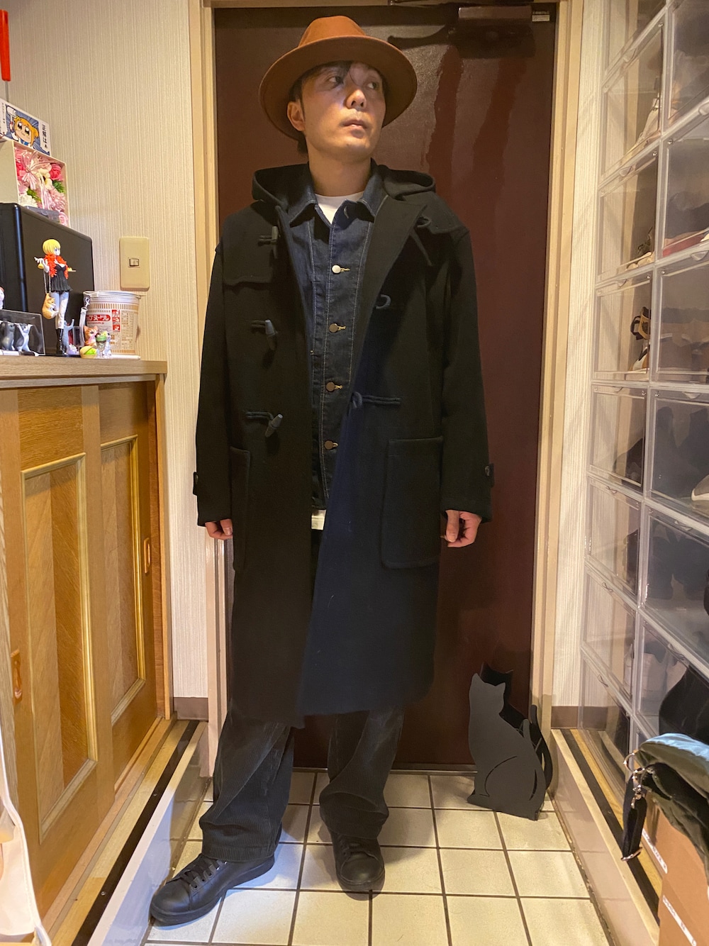 ブルー系のデニムジャケット、ブラック系のダッフルコート、ホワイト系のTシャツ/カットソーを着用したメンズの冬コーディネートの1枚目の写真