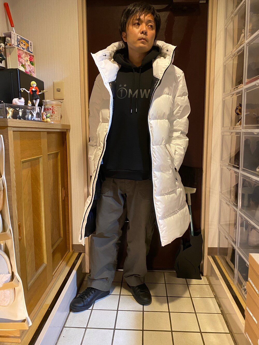 ホワイト系のダウンジャケット/コート、ブラック系のパーカー、グリーン系のパンツを着用したメンズの冬コーディネートの1枚目の写真