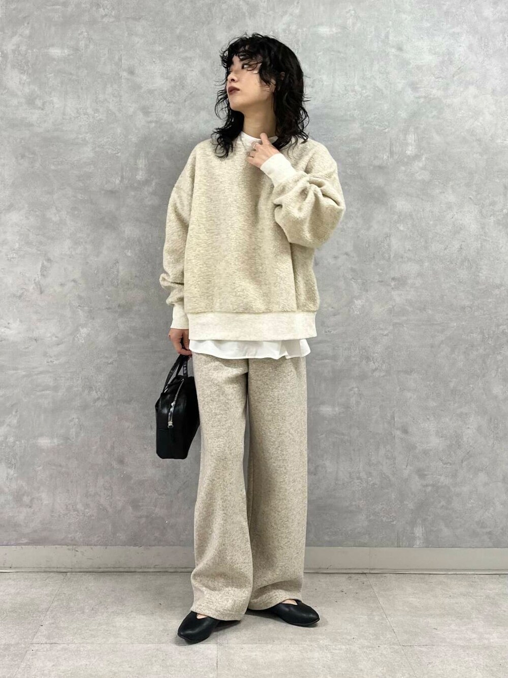 ブラック系のショルダーバッグ、ベージュ系のその他パンツ、ベージュ系のTシャツ/カットソーを着用したレディースの冬コーディネートの1枚目の写真