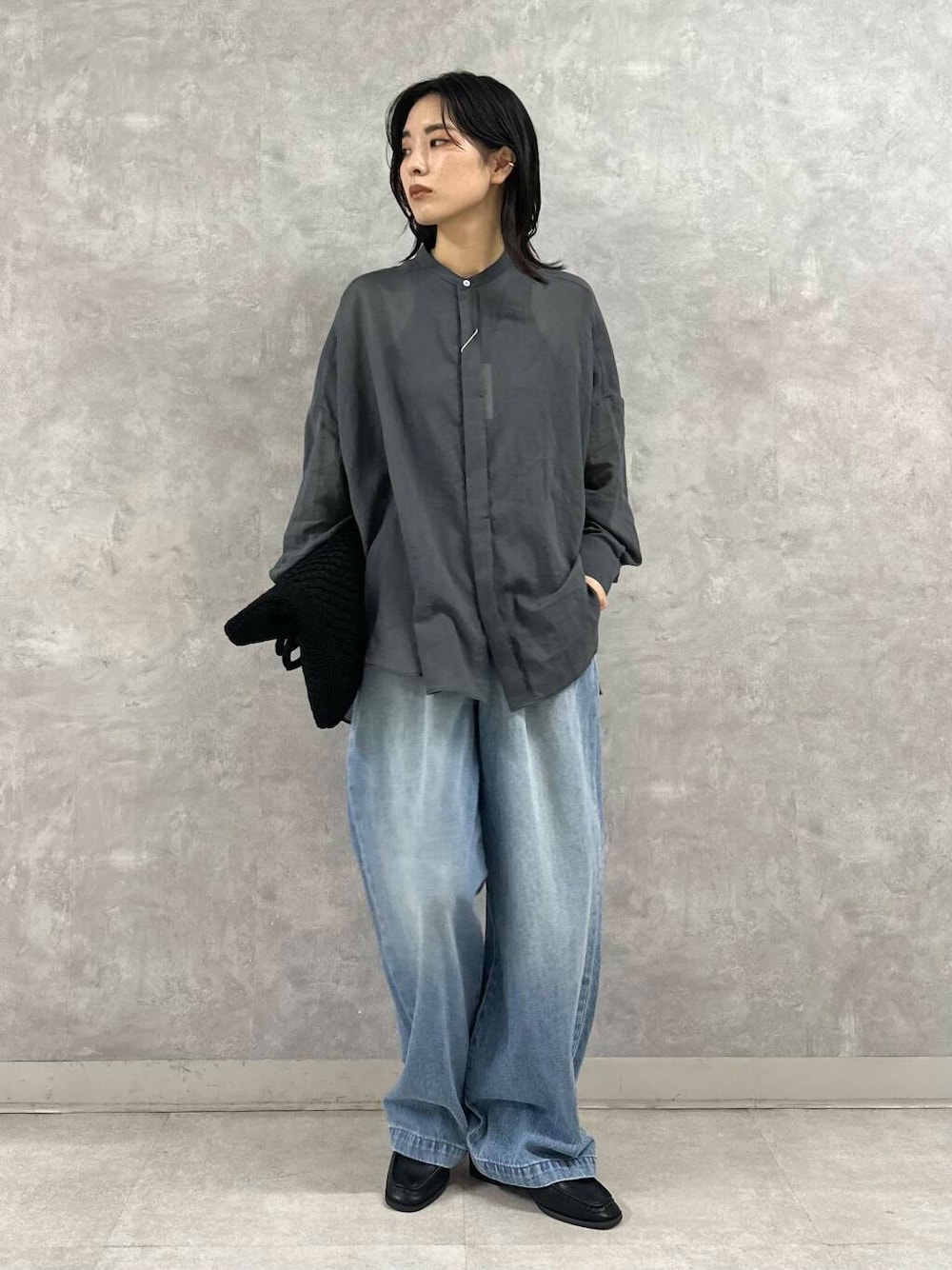 ブラック系のサンダル、ブルー系のデニムパンツ、ブラック系のトートバッグを着用したレディースの夏コーディネートの1枚目の写真