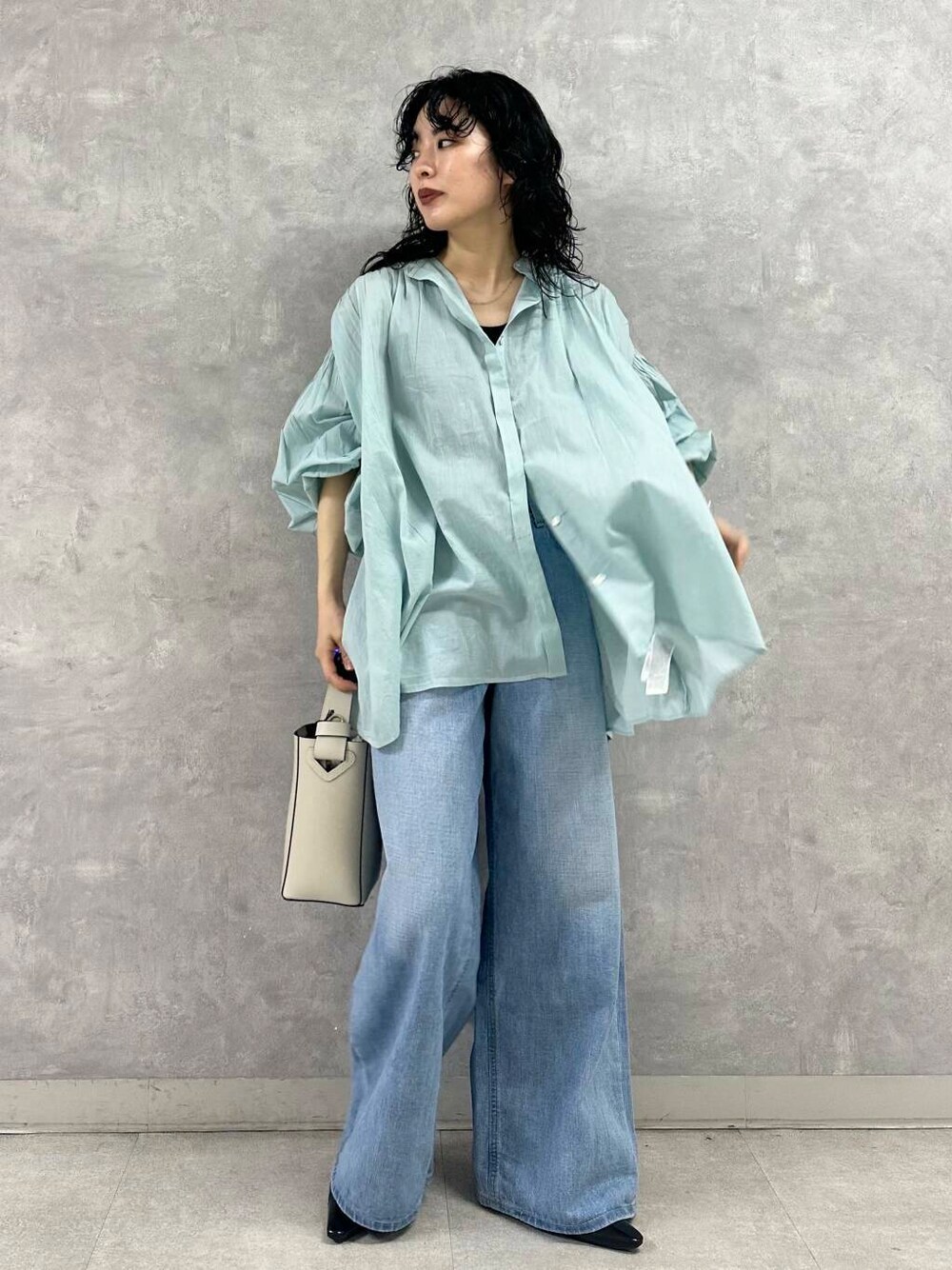 ブルー系のデニムパンツ、ホワイト系のトートバッグ、グリーン系のシャツ/ブラウスを着用したレディースの春コーディネートの1枚目の写真