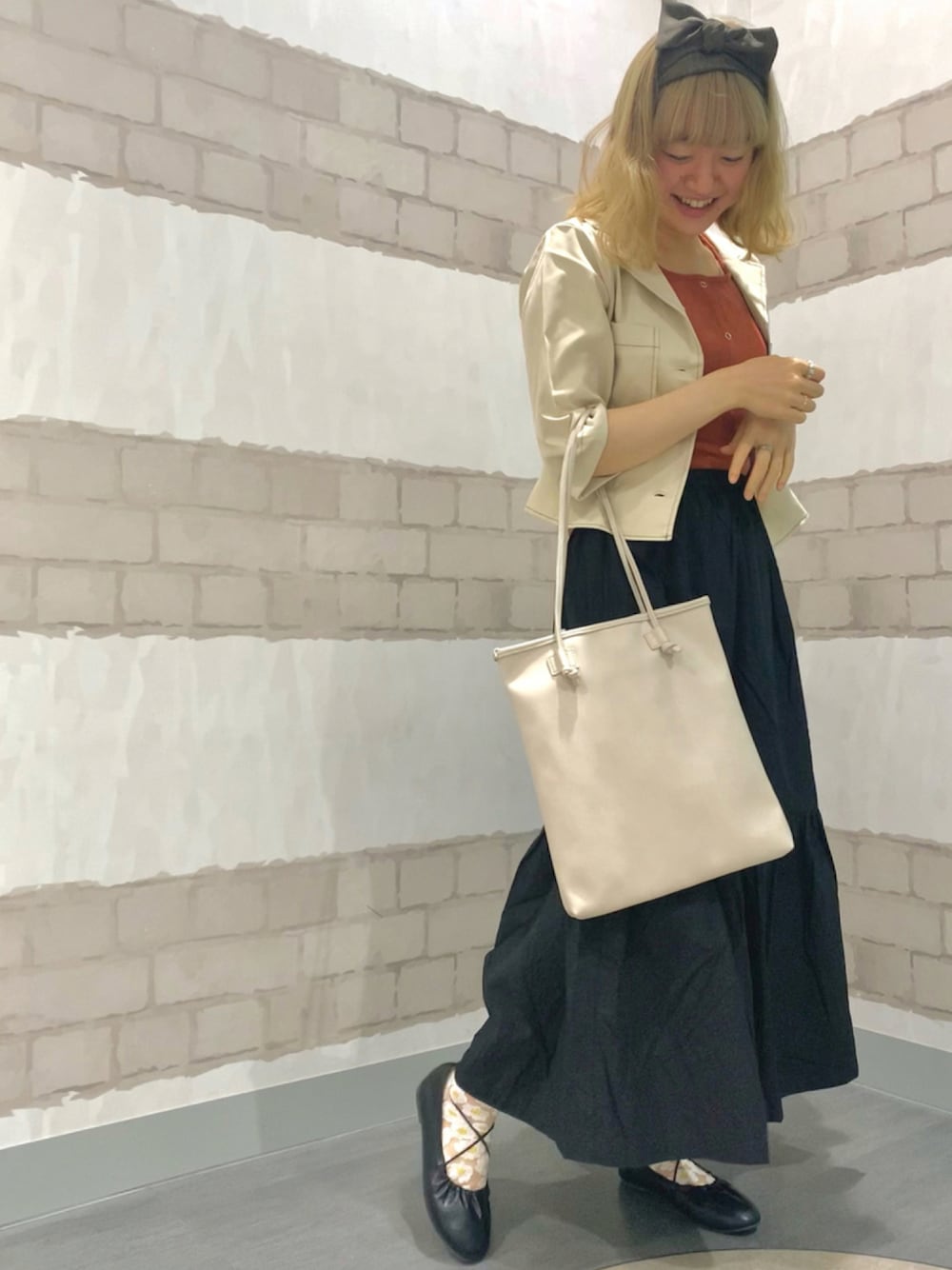 ブラック系のスカート、ホワイト系のシャツ/ブラウス、オレンジ系のタンクトップを着用したレディースの夏コーディネートの1枚目の写真