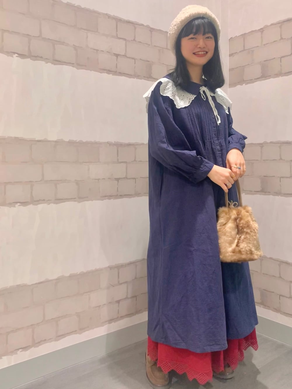 ブルー系のワンピース、ベージュ系のブーツ、レッド系のスカートを着用したレディースの秋コーディネートの1枚目の写真