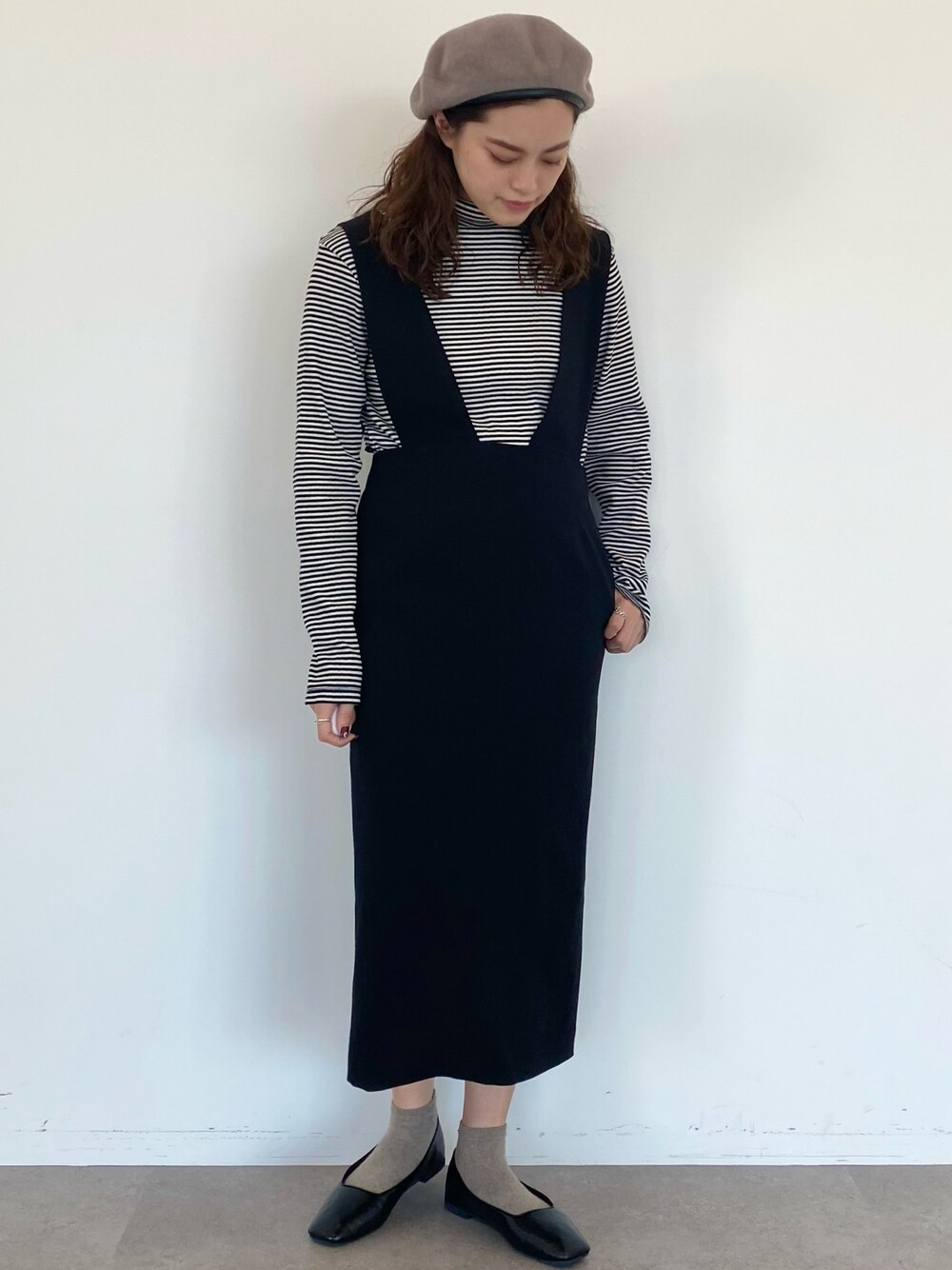 ブラック系のTシャツ/カットソー、ブラック系のジャンパースカート、ブラック系のパンプスを着用したレディースの秋コーディネートの1枚目の写真