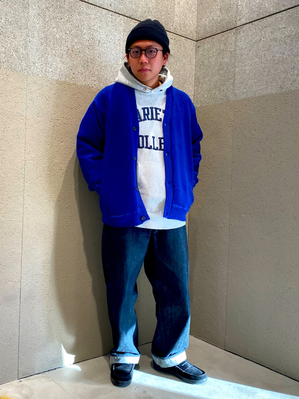 グレー系のパーカー、ブルー系のカーディガン/ボレロ、ブルー系のデニムパンツを着用したメンズの冬コーディネートの1枚目の写真