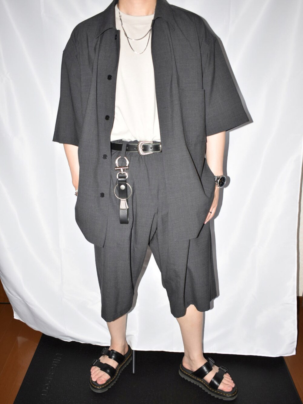 ブラック系のサンダル、グレー系のその他パンツ、ベージュ系のTシャツ/カットソーを着用したメンズの夏コーディネートの1枚目の写真