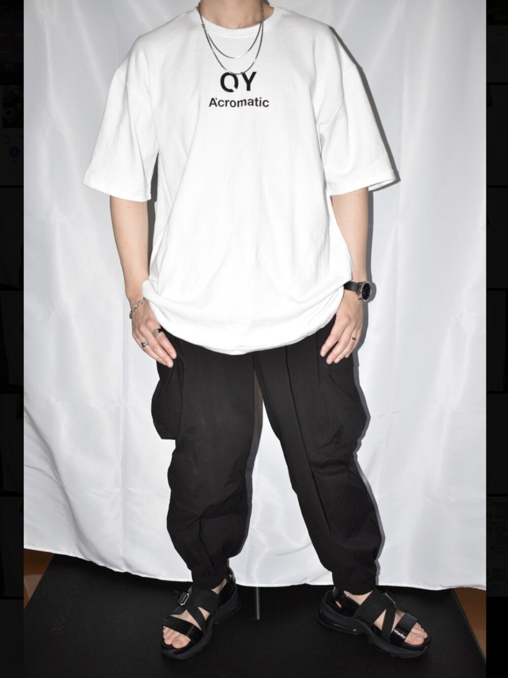 ホワイト系のTシャツ/カットソー、ブラック系のカーゴパンツ、ブラック系のサンダルを着用したメンズの夏コーディネートの1枚目の写真
