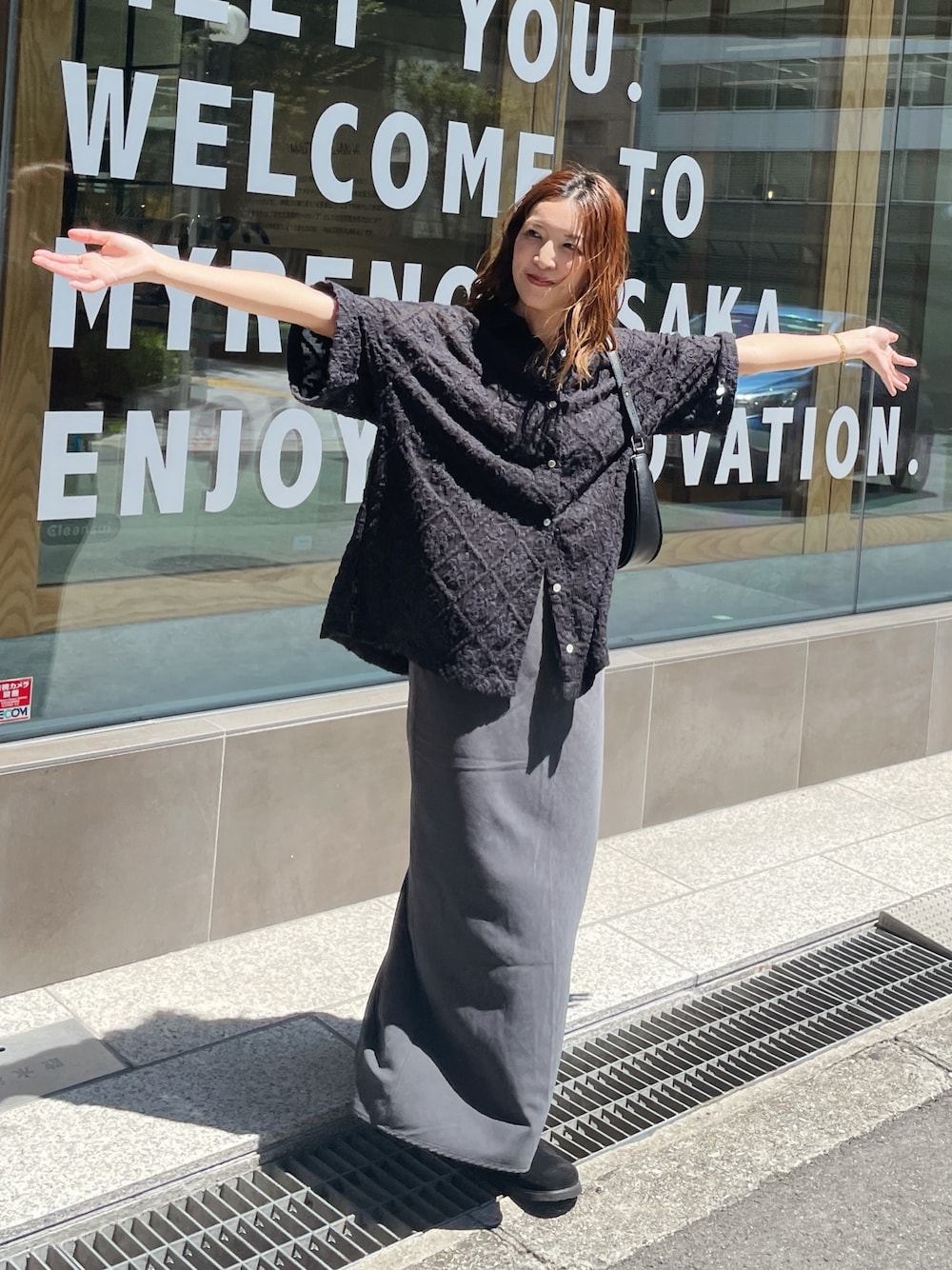 ブラック系のシャツ/ブラウス、グレー系のスカート、ブラック系のスリッポンを着用したレディースの秋コーディネートの1枚目の写真