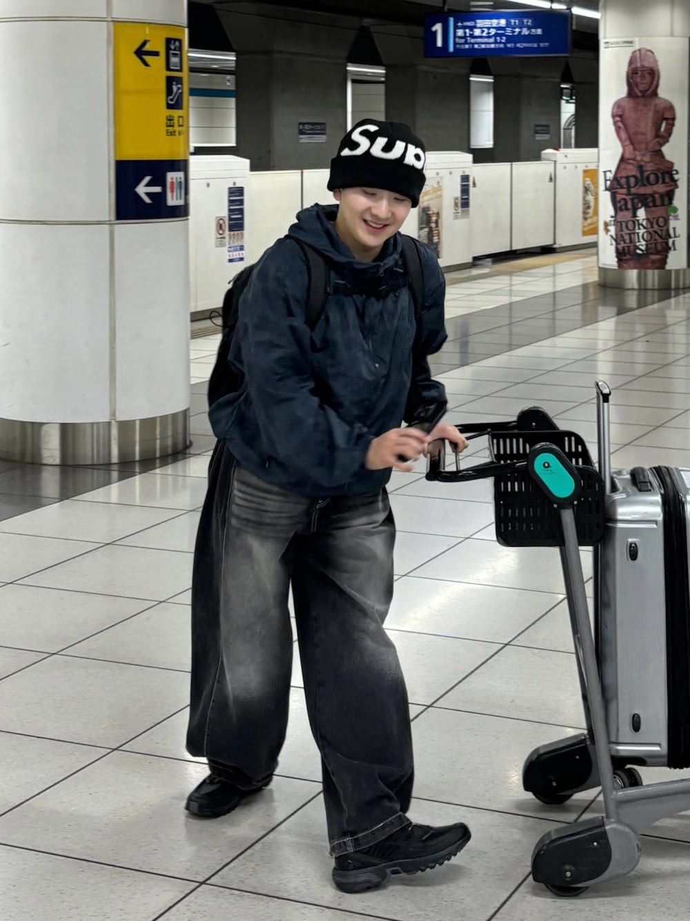 ブラック系のデニムパンツ、ブラック系のスニーカー、ブルー系のマウンテンパーカーを着用したメンズの夏コーディネートの1枚目の写真