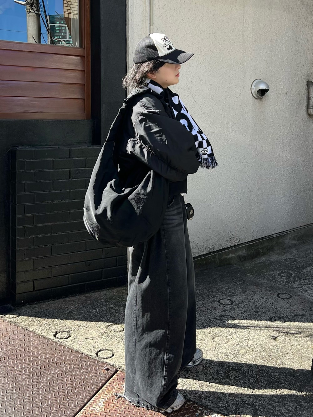 ブラック系のショルダーバッグ、グレー系のデニムパンツ、ブラック系のMA-1を着用したメンズの冬コーディネートの1枚目の写真