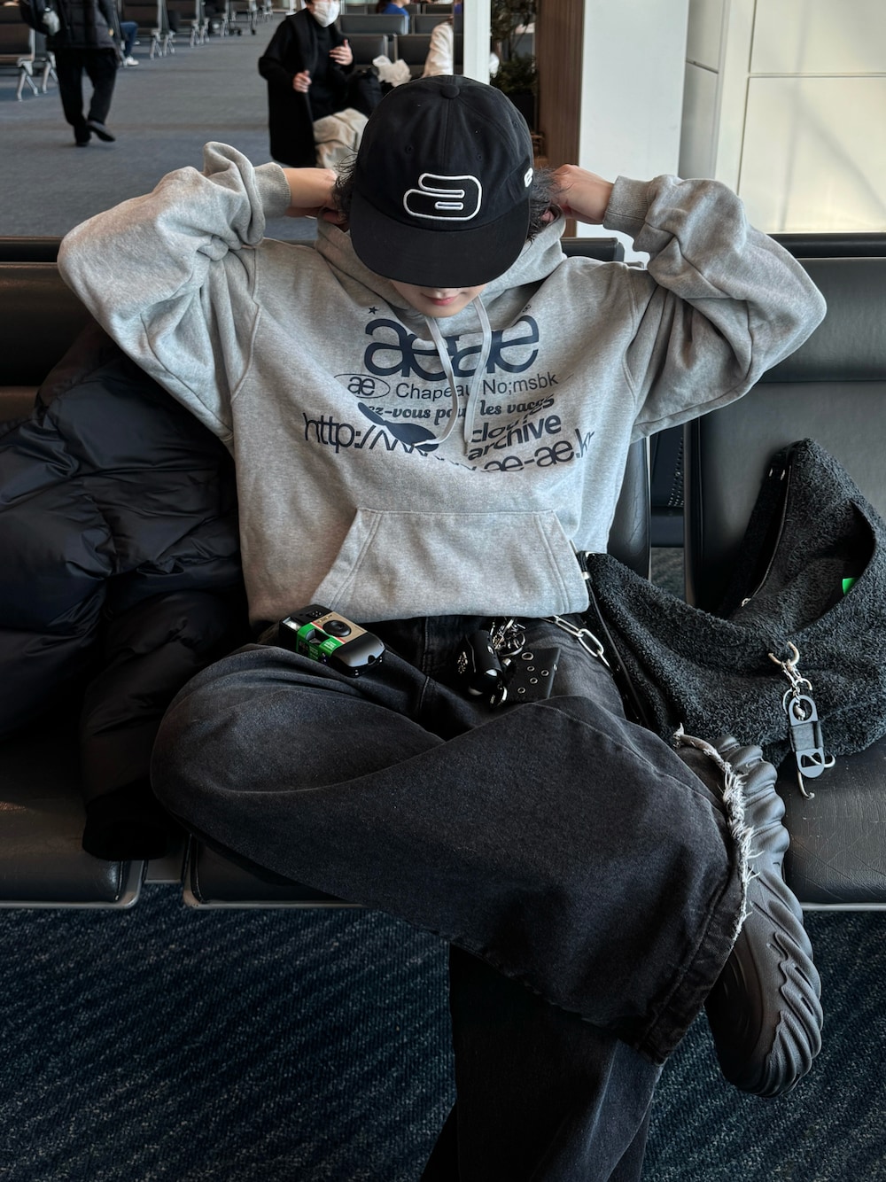 ブラック系のダウンジャケット/コート、ブラック系のスニーカー、グレー系のデニムパンツを着用したメンズの冬コーディネートの1枚目の写真