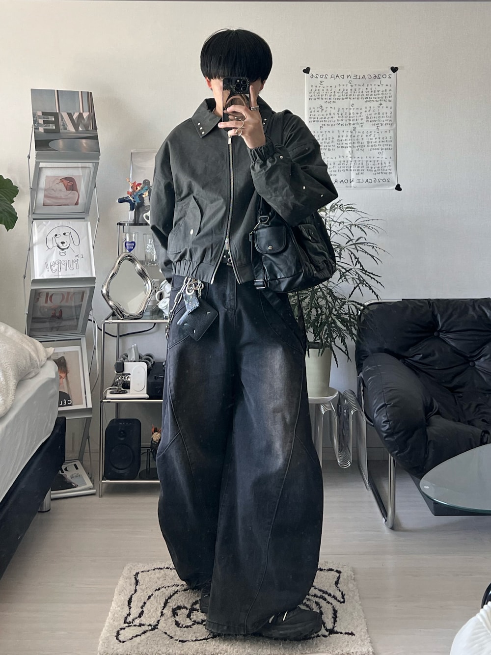 ブラック系のブルゾン、ブラック系のデニムパンツ、ブラック系のスニーカーを着用したメンズの春コーディネートの1枚目の写真