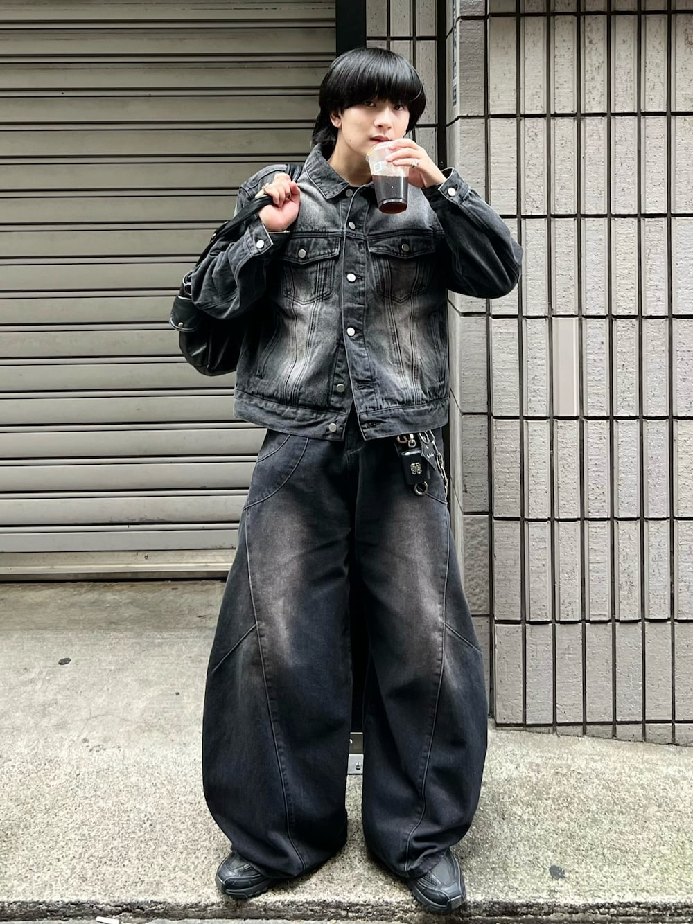 ブラック系のデニムジャケット、ブラック系のデニムパンツ、ブラック系のショルダーバッグを着用したメンズの秋コーディネートの1枚目の写真