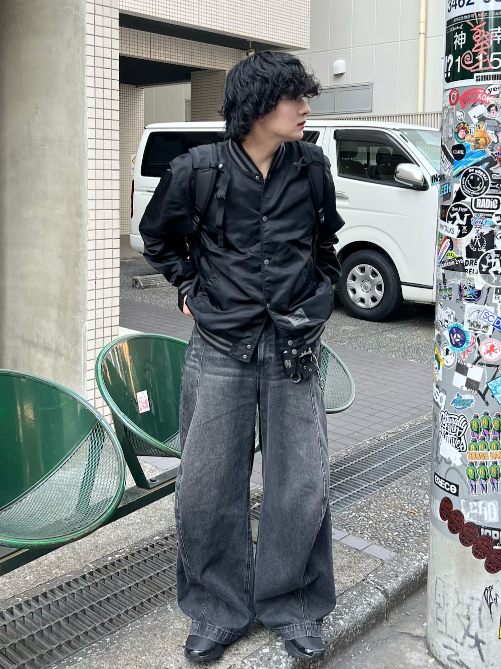 ブラック系のデニムパンツ、ブラック系のブルゾン、ブラック系のバックパック/リュックを着用したメンズの春コーディネートの1枚目の写真