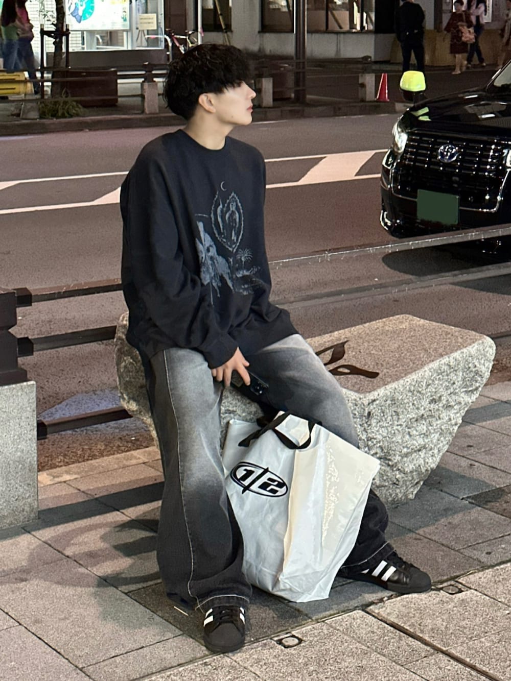 ブラック系のデニムパンツ、ブラック系のスニーカー、ブラック系のスウェットを着用したメンズの秋コーディネートの1枚目の写真