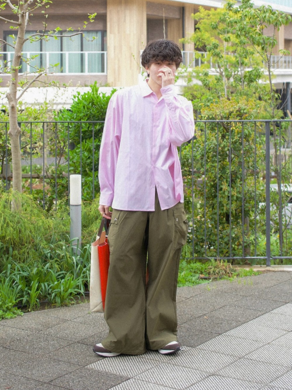 ピンク系のシャツ/ブラウス、グリーン系のカーゴパンツ、ホワイト系のトートバッグを着用したメンズの春コーディネートの1枚目の写真