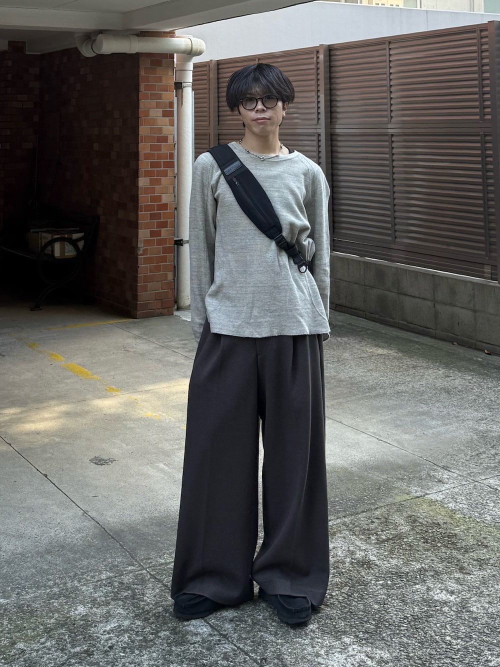 グレー系のTシャツ/カットソー、ブラウン系のスラックス、ブラック系のモカシン/デッキシューズを着用したメンズの秋コーディネートの1枚目の写真