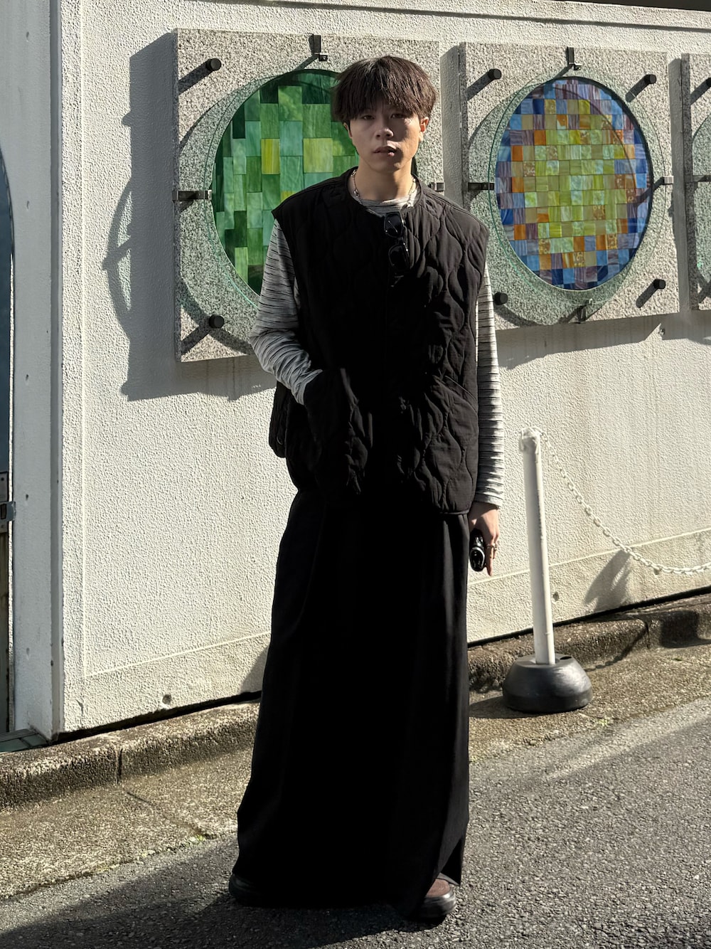 ブラック系のその他アウター、グレー系のTシャツ/カットソー、グレー系のスラックスを着用したメンズの春コーディネートの1枚目の写真