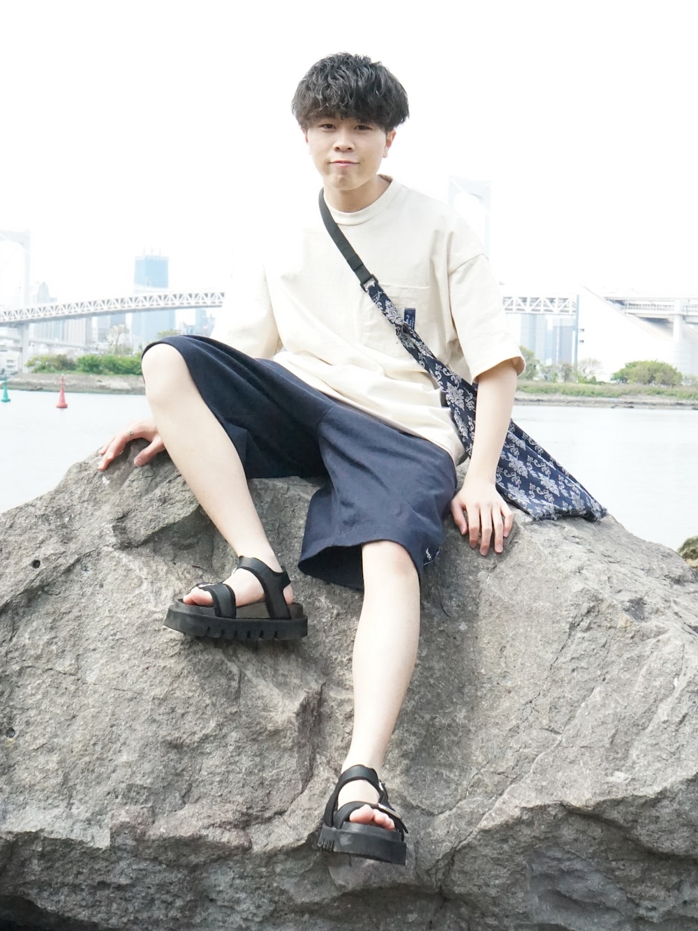 ベージュ系のTシャツ/カットソー、ブルー系のスウェットパンツ、ブルー系のショルダーバッグを着用したメンズの春コーディネートの1枚目の写真