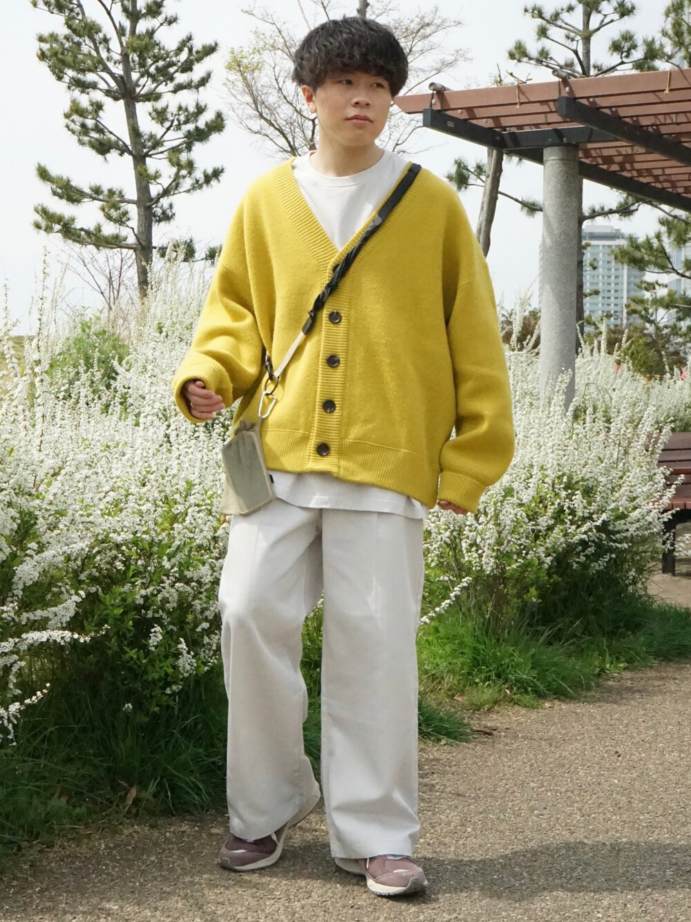 イエロー系のカーディガン/ボレロ、ホワイト系のチノパンツ、ベージュ系のショルダーバッグを着用したメンズの春コーディネートの1枚目の写真