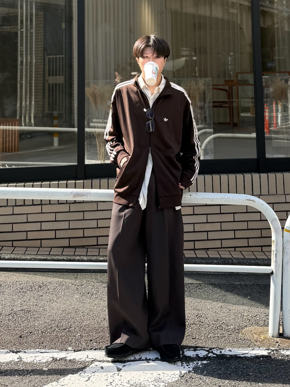 ブラウン系のジャージ、ブラック系のモカシン/デッキシューズ、ブラウン系のサングラスを着用したメンズの秋コーディネートの1枚目の写真