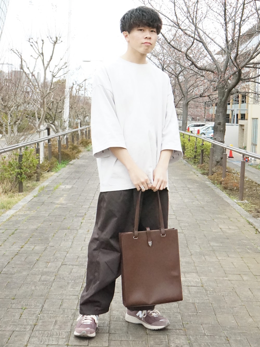 グレー系のTシャツ/カットソー、ブラウン系のカーゴパンツ、ブラウン系のトートバッグを着用したメンズの春コーディネートの1枚目の写真