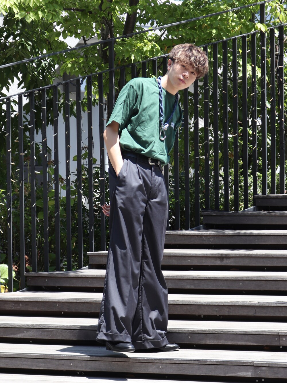 グリーン系のTシャツ/カットソー、グレー系のスラックス、ブルー系のウォレットチェーンを着用したメンズの夏コーディネートの1枚目の写真