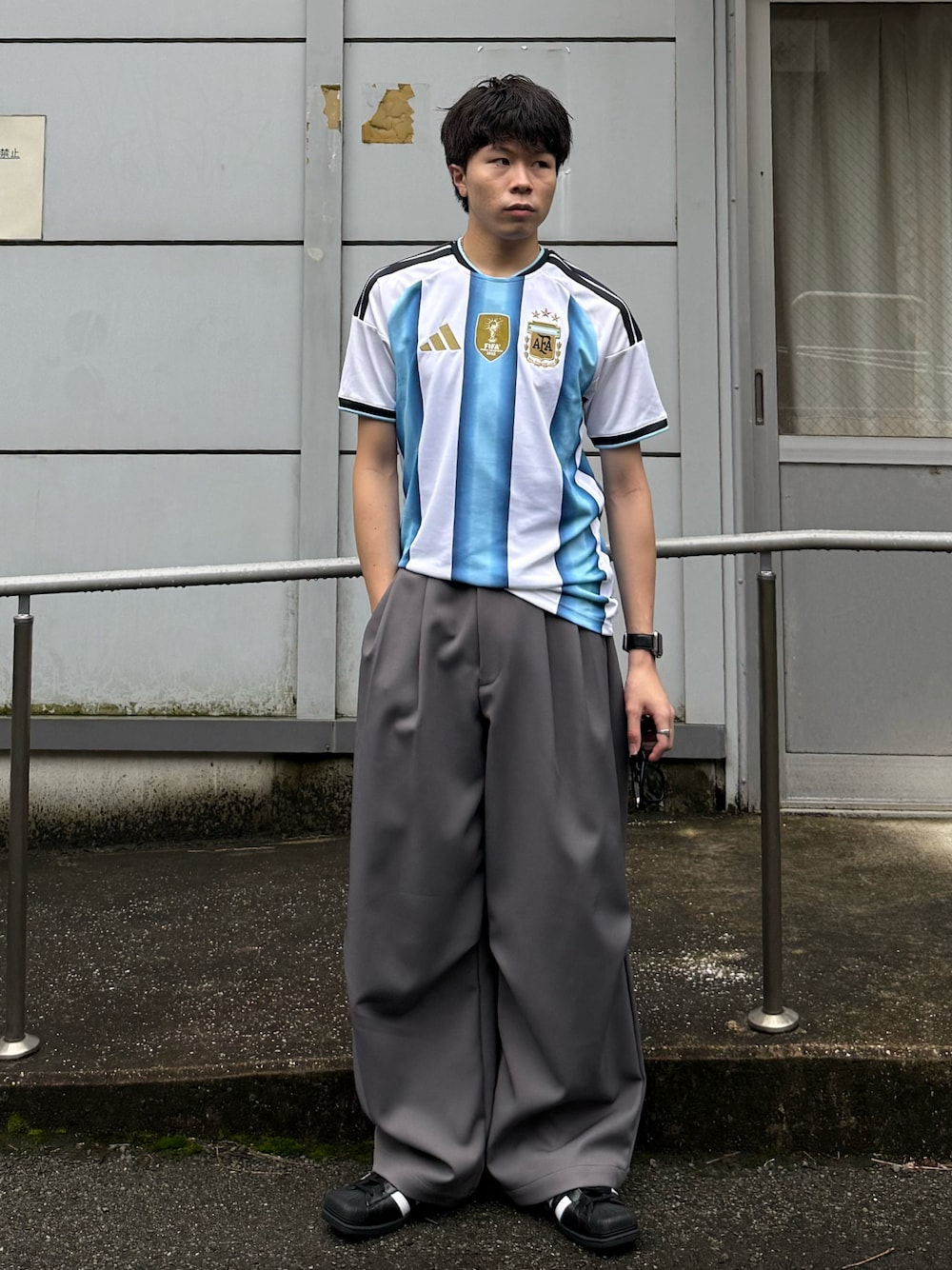 ホワイト系のTシャツ/カットソー、グレー系のパンツ、ブラック系のスニーカーを着用したメンズの夏コーディネートの1枚目の写真