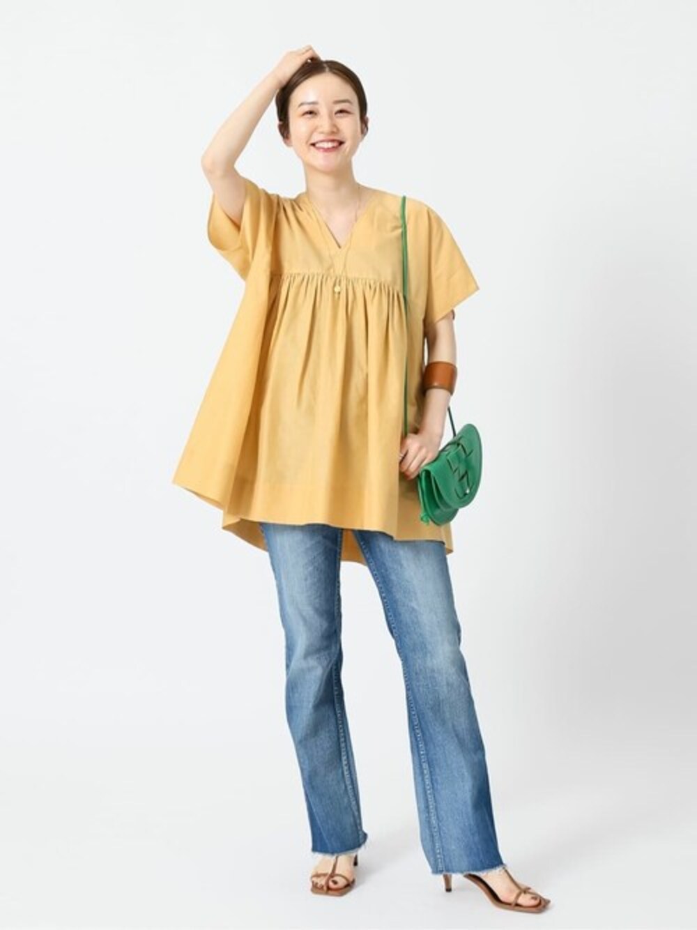 オレンジ系のシャツ/ブラウス、イエロー系のサンダル、イエロー系のブレスレットを着用したレディースの夏コーディネートの1枚目の写真