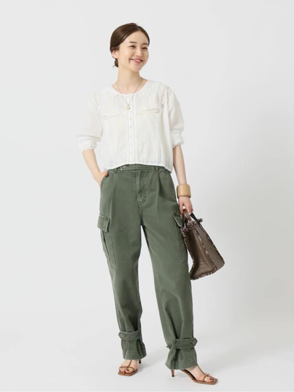 イエロー系のサンダル、ブラウン系のハンドバッグ、ベージュ系のブレスレットを着用したレディースの夏コーディネートの1枚目の写真