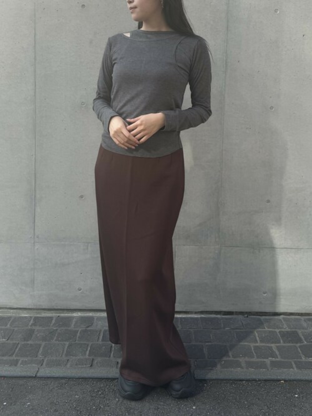 グレー系のTシャツ/カットソー、ブラウン系のスカート、シルバー系のピアス(両耳用)を着用したレディースの秋コーディネートの1枚目の写真