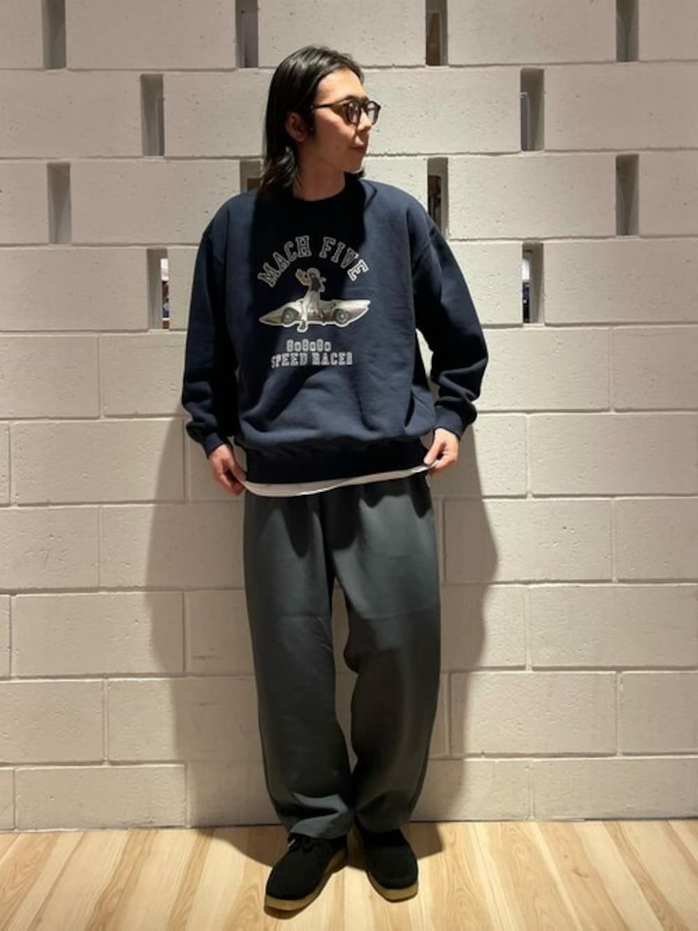 ブルー系のスウェット、グレー系のスラックス、ブラック系のブーツを着用したメンズの春コーディネートの1枚目の写真