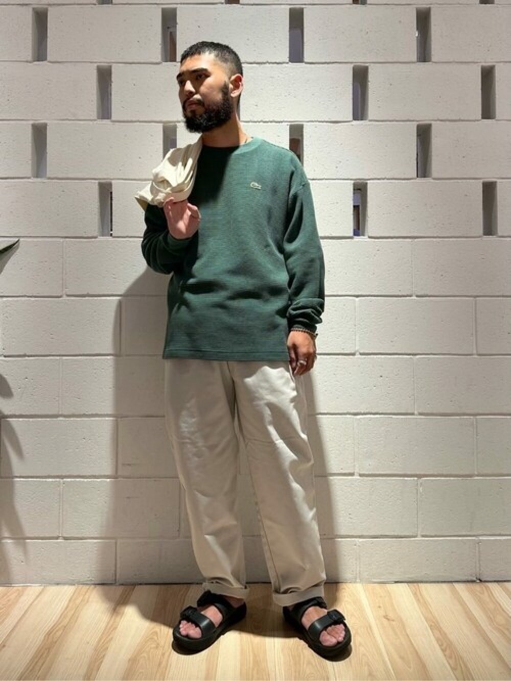 グリーン系のTシャツ/カットソー、グレー系のチノパンツを着用したメンズの秋コーディネートの1枚目の写真