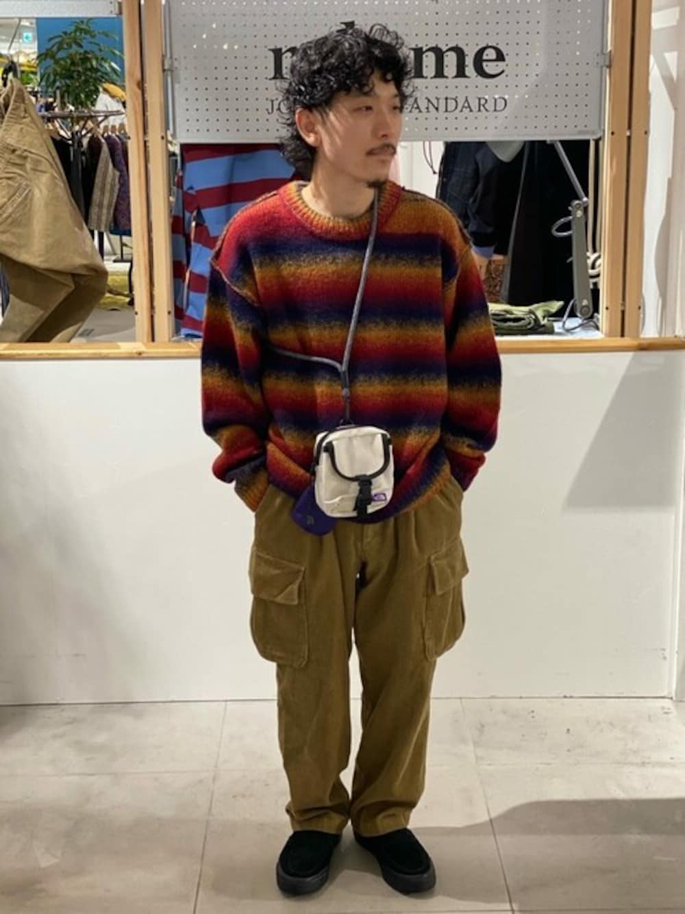 レッド系のニット/セーター、イエロー系のカーゴパンツ、ブラック系のスニーカーを着用したメンズの秋コーディネートの1枚目の写真