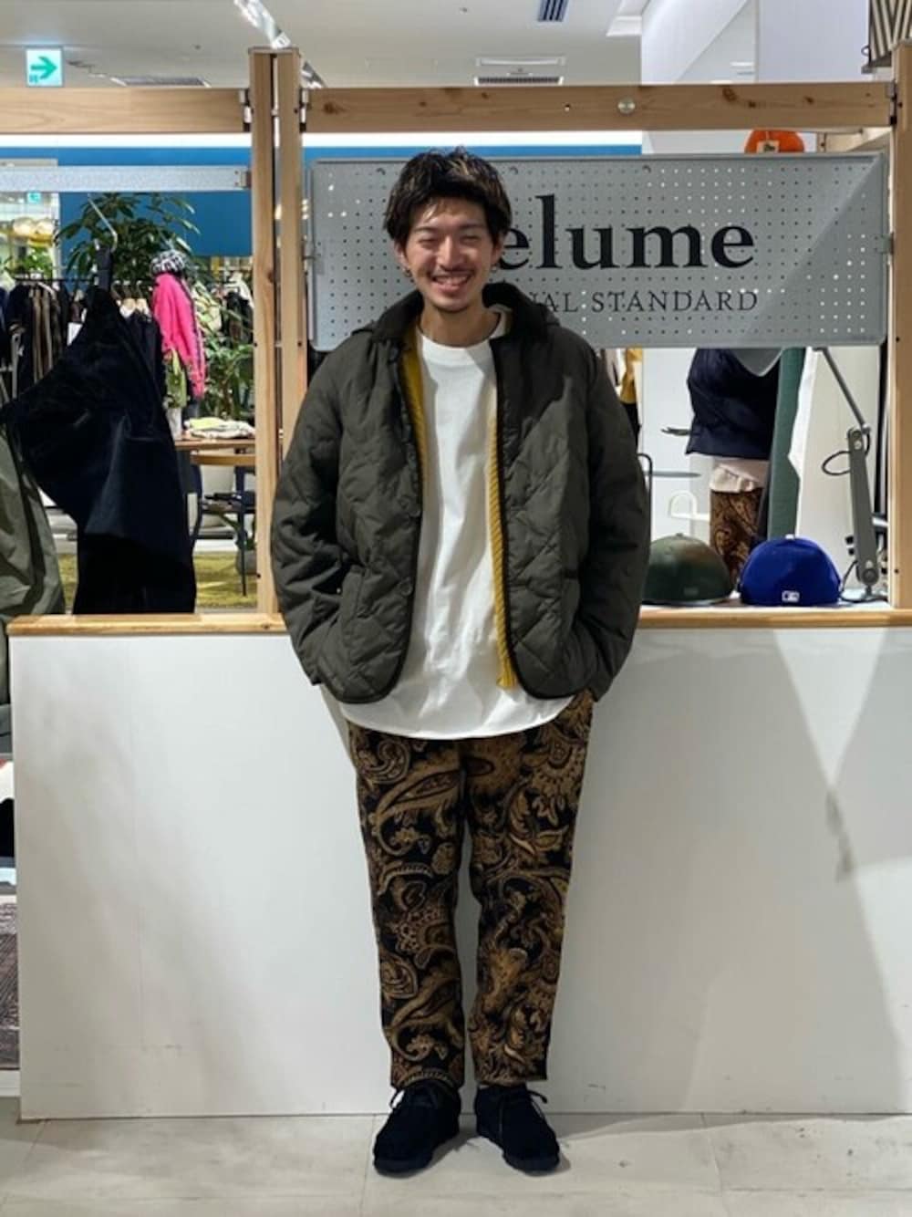 グリーン系のダウンジャケット/コート、ブラック系のスラックス、ブラック系のモカシン/デッキシューズを着用したメンズの秋コーディネートの1枚目の写真