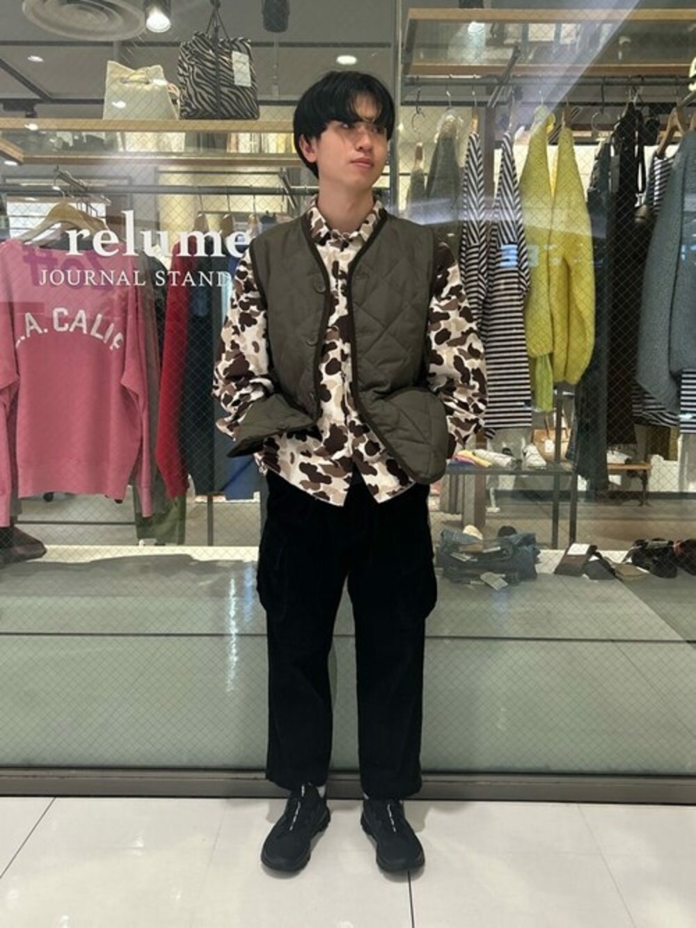 グリーン系のダウンベスト、ブラック系のカーゴパンツを着用したメンズの秋コーディネートの1枚目の写真